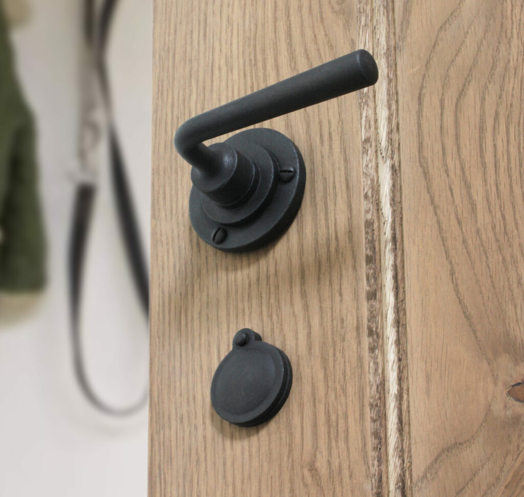 Black lever handle on oak door