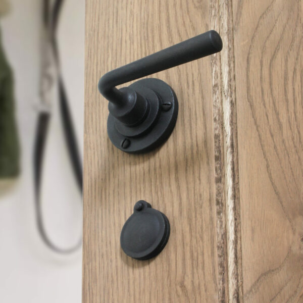 Black lever handle on oak door